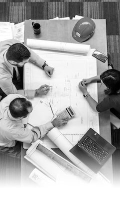 People at a Table Working With Blueprints